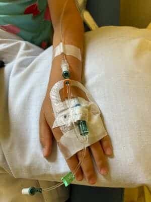 brazo de niña con via en la mano